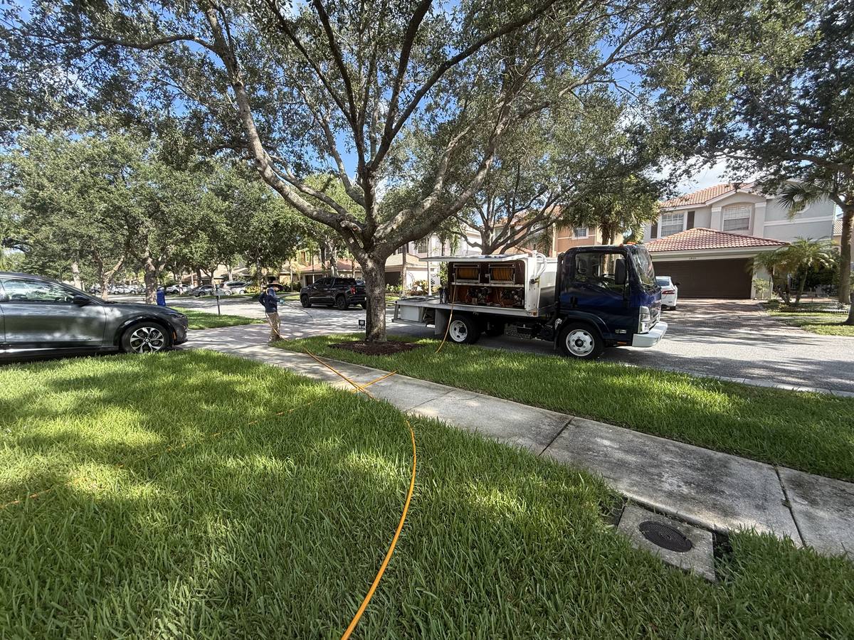 Technician treating a shaded lawn from the service truck in Wellington
