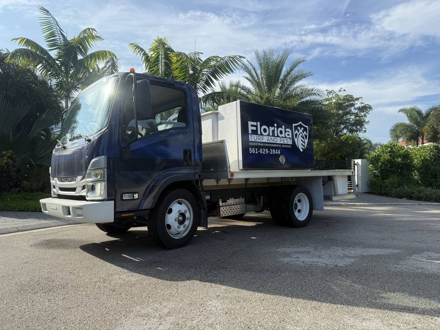 Florida Turf and Pest navy service truck parked among palm trees